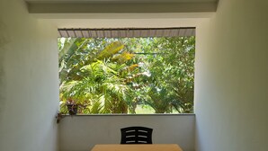 A small room with a single table and chair, a window with a view of lush greenery. - Mealanies House (Unawatuna)