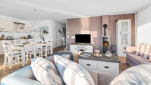 En moderne stue med sofa, fjernsyn og pejs.