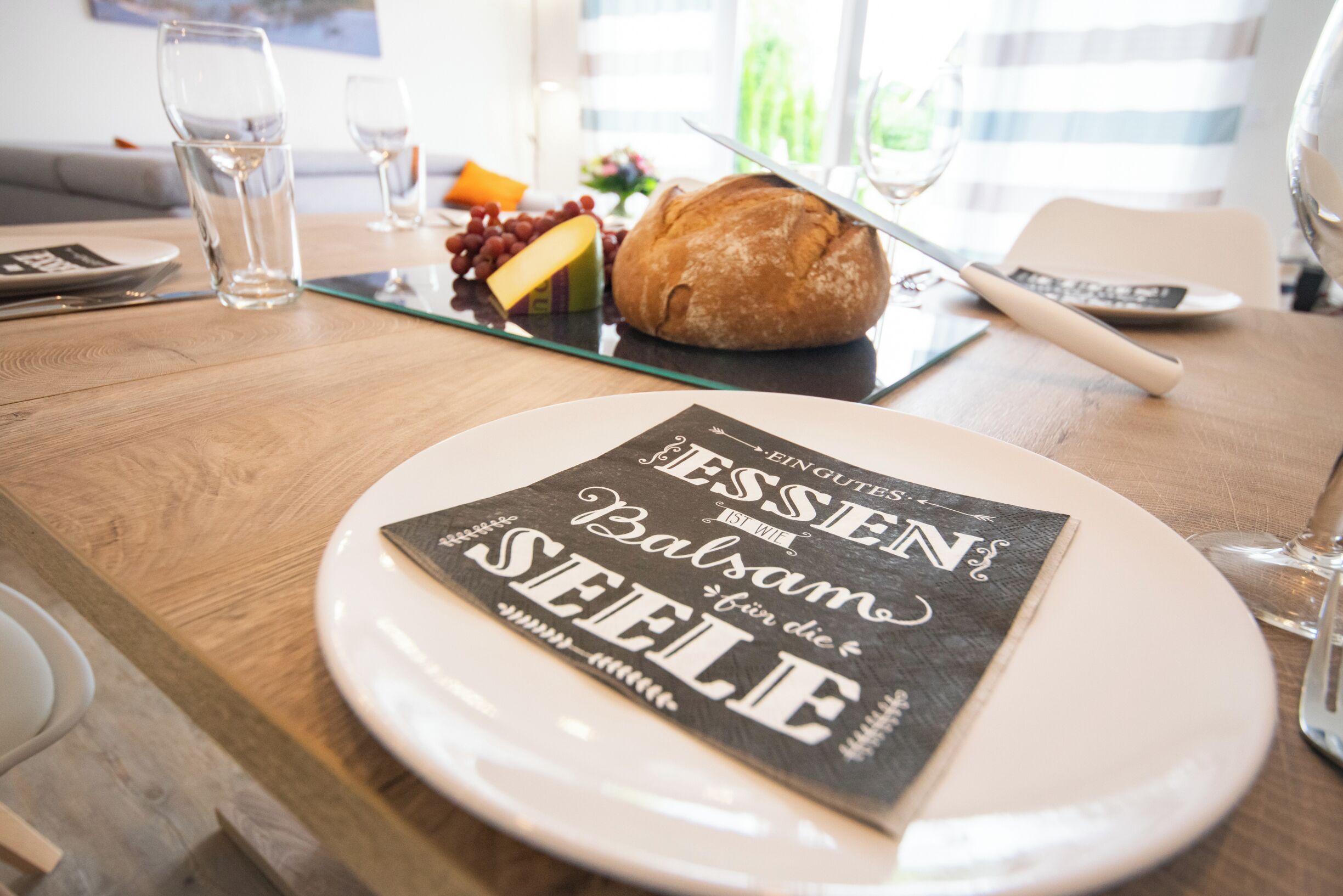 Une table à manger avec une assiette de nourriture, un pain et un menu.