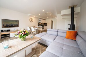 Casa Comfort | Area soggiorno | TV a schermo piatto 55 pollici con canali via cavo, caminetto