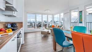 A modern kitchen with a built-in oven and a dining area with a view of the city. - Stunning ship in Olpenitz with sauna (Olpenitz)