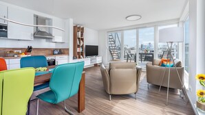 A modern living space with a kitchen, dining area, and seating area with a city view. - Stunning ship in Olpenitz with sauna (Olpenitz)
