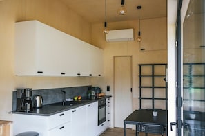 Køleskab, kaffe-/temaskine, køkkentøj/tallerkener/redskaber, spisebord