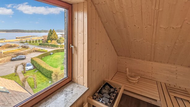 A wooden interior with a view of a green landscape and a road. - Cozy apartment in Boren with sauna (Boren)