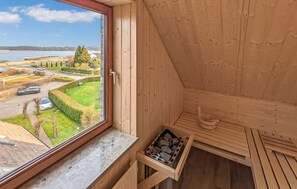 Interior de madera con vistas a un paisaje verde y una carretera.