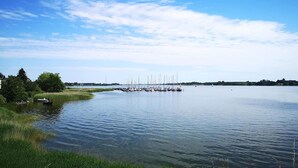 A calm lake with a dock and sailboats. - Cozy apartment in Boren with sauna (Boren)