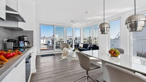 Una cucina moderna con zona pranzo, ampie finestre e vista sulla città.