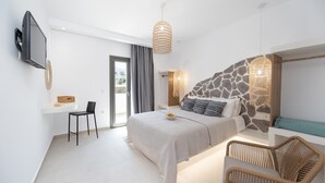A modern bedroom with a bed, a desk, a chair, and a TV. - BLUE SEA NAXOS  (Naxos)