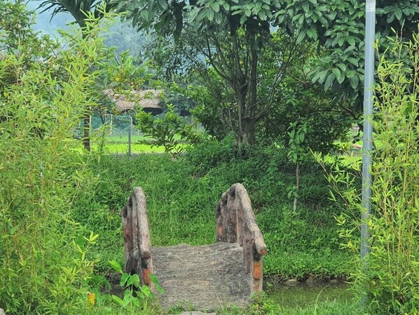 A rustic wooden bridge in a lush green garden.