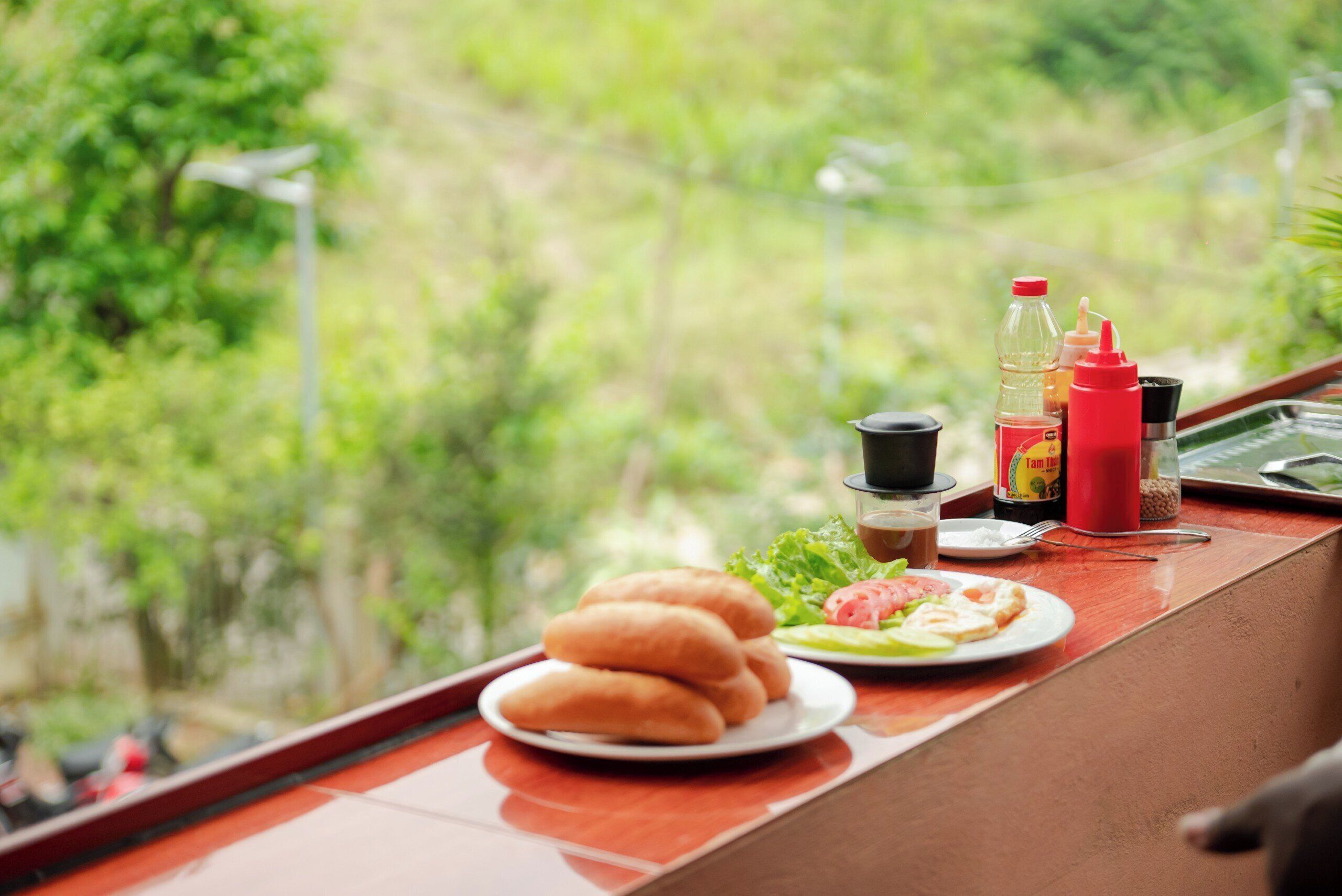A dining table with a plate of food, condiments, and a bottle of water.