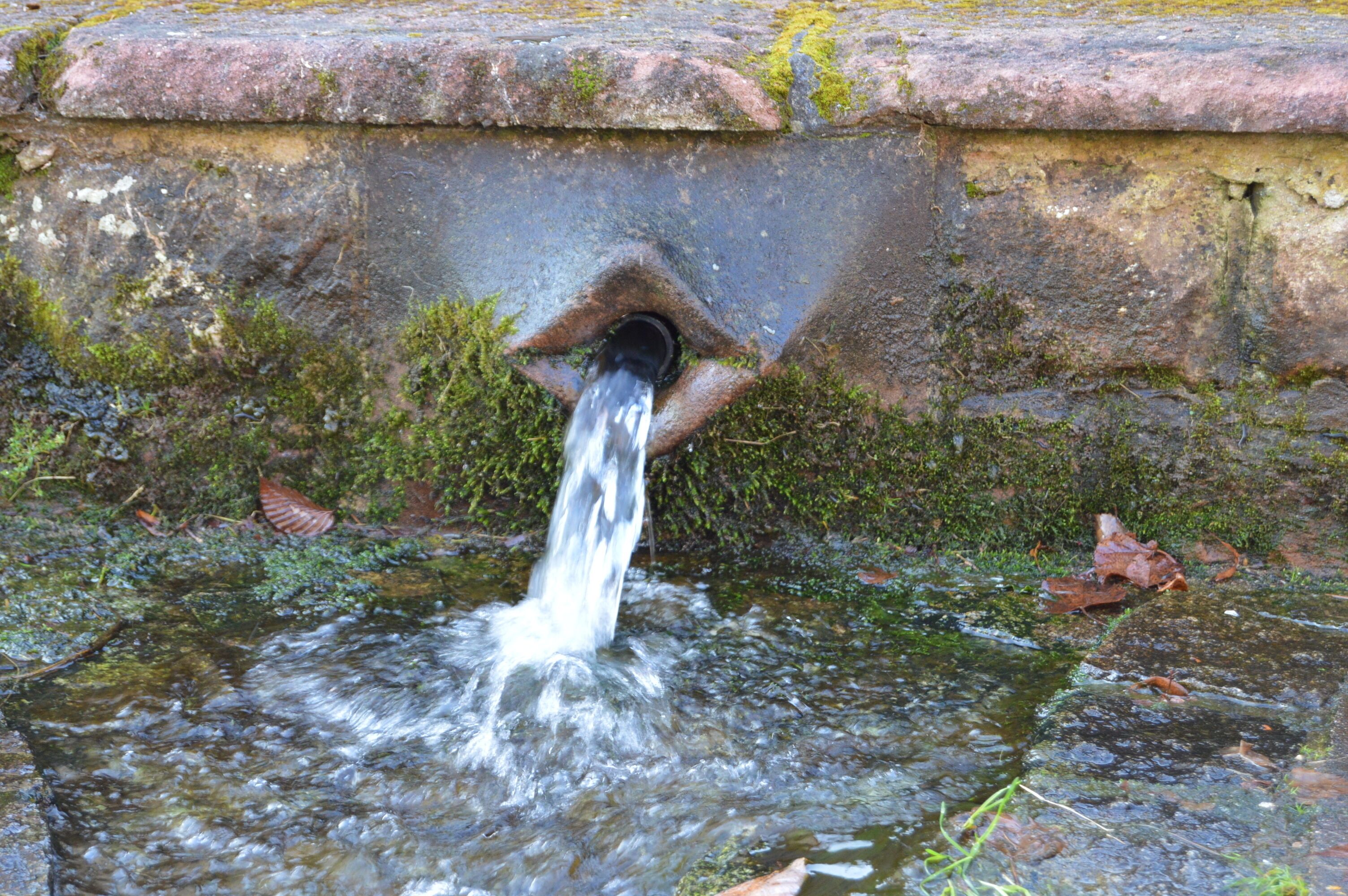Una struttura in pietra con un bocchetta d'acqua.