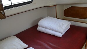 A compact bunk bed with a red mattress and white bedding. - Exclusive Stay on Triton 860 Fly (Pontailler-sur-Saône)