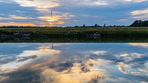 A calm body of water reflecting clouds and a sunset. - Exclusive Stay on Triton 860 Fly (Pontailler-sur-Saône)