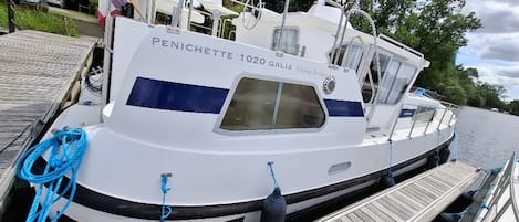 A white boat named 'Penichette 1020 Galia' docked at a wooden pier.