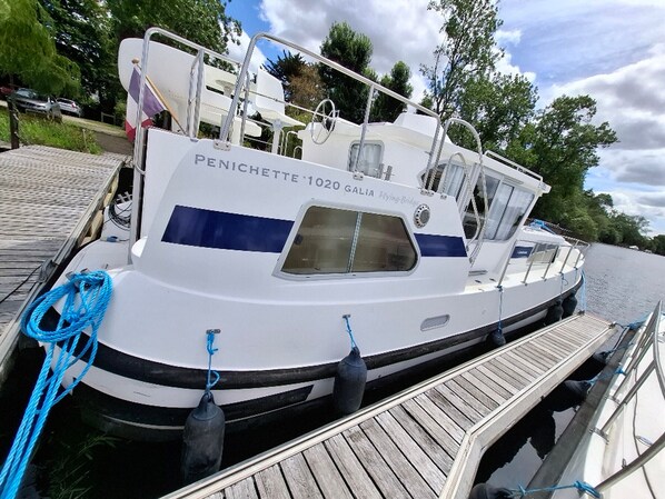 A white boat named 'Penichette 1020 Galia' docked at a wooden pier.