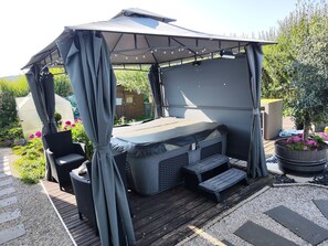 A covered outdoor seating area with a bench, a table, and a canopy. - Au Ch'ti Suisse  (Autechaux)