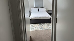A bedroom with a bed, a nightstand, and a window. - Apartment - Sleeps 4 & Free Parking (London)