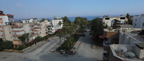 A residential area with multiple apartment buildings, a clear view of the sea, and a parking lot.