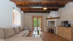 Una sala de estar con un sofá, una mesa de centro con un cactus, una chimenea y un televisor.