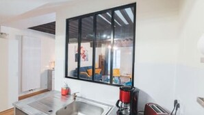 A modern kitchen with a built-in sink, a coffee maker, and a toaster. - Charming townhouse with a covered and furnished interior patio (Tournus)