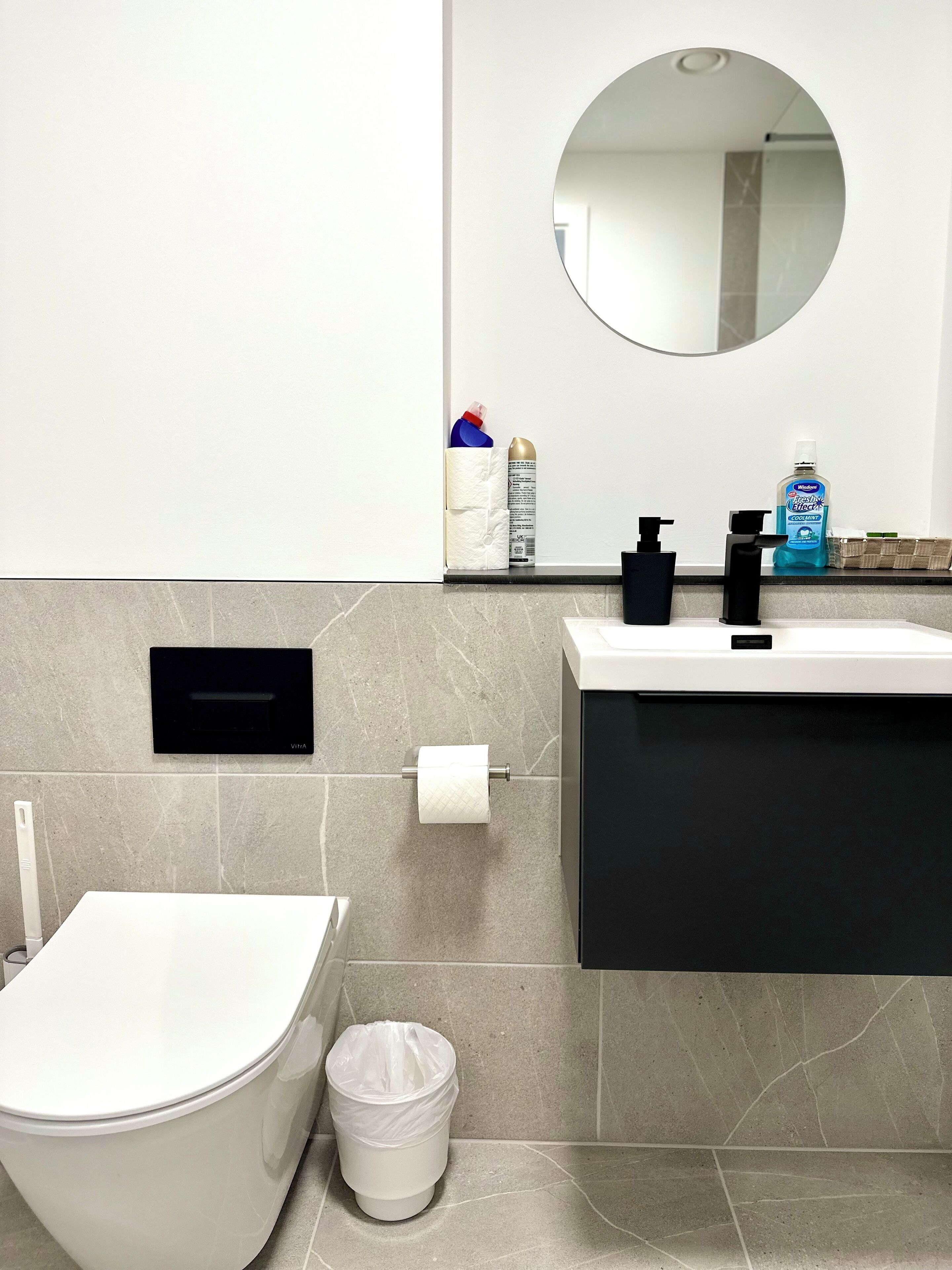 Une salle de bain moderne équipée de toilettes, d’un bidet et d’une poubelle.