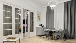 A modern dining area with a round table and chairs, a coffee machine, and a decorative wall piece.