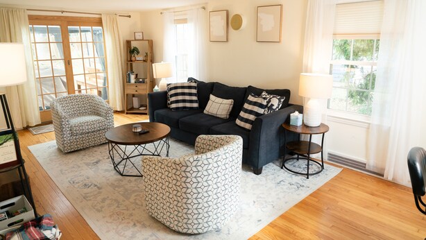 Una sala de estar con sofá, sillón, mesa de centro y mesita auxiliar.