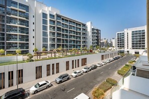 A modern multi-story building with a parking area in front.