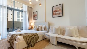 Ein Hotelzimmer mit einem Bett, einer Couch, einem Schreibtisch und einem Stuhl. An der Wand hängen zwei Bilder.