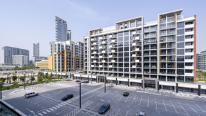 Ein modernes mehrstöckiges Gebäude mit Parkplatz davor.