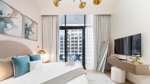Ein modernes Hotelzimmer mit einem großen Bett, einem Fernseher und Blick auf die Stadt.