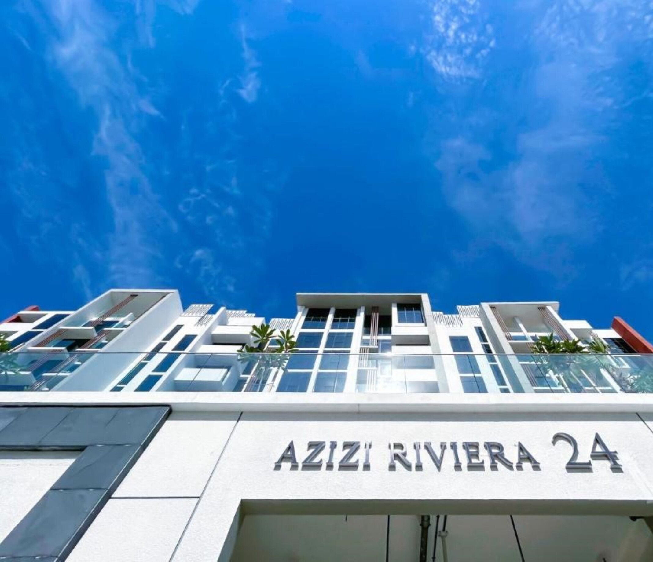 A modern building with the sign "AZIZI RIVIERA 24" indicating a hotel or resort.