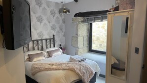 Un dormitorio con cama, armario, ventana y espejo.