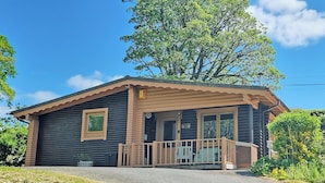 A small, single-story cabin with a porch, a window, and a door. - 3 bedroom accommodation in Llanfynydd (Llanfynydd)