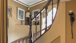 Un escalier avec une rampe en bois et une moquette à motifs.