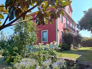 A red building with a balcony, surrounded by greenery and a stone wall. - Solar da Motta
4 bedroom villa in Douro - WiFi, pool, BBQ, free parking (Baião)