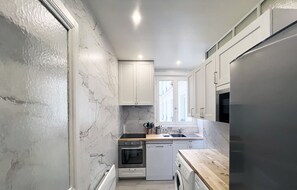 A compact kitchen with white cabinets, a stainless steel refrigerator, a dishwasher, and a washing machine. - Urban Flat 180 - Nice Apartment in the center of Le Marais district (París)