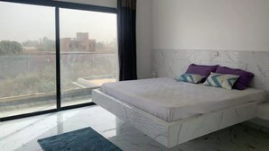 Una camera da letto moderna con un letto grande, vista sulla città e condizionatore d'aria.
