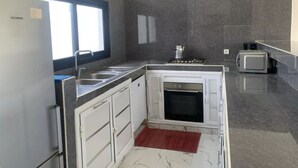 Una cucina moderna con forno integrato, microonde e piano cottura a gas.