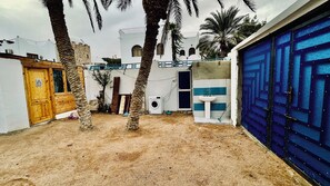 Un patio con lavadora, lavabo y una puerta azul.