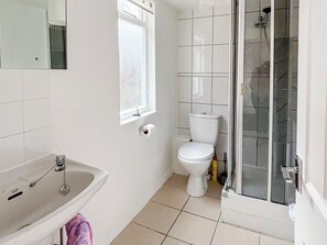 Une salle de bain avec des toilettes, un lavabo et une douche.