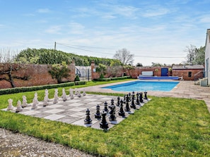A pool with a chessboard set up in the foreground.