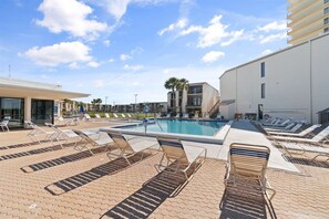 Un espace piscine avec des chaises longues et une piscine.