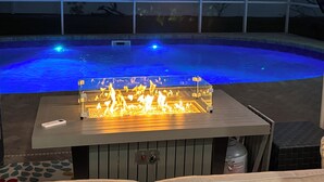 En swimmingpool med integreret ildsted og frit udsyn til det omkringliggende område.