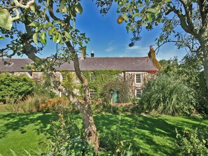 A stone house with ivy-covered walls, a well-maintained lawn, and a clear blue sky. - Rock Farm House Alnwick (Rock near Alnwick)
