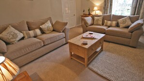 A living room with two sofas, a coffee table, and a lamp.