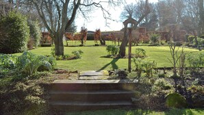 A garden with a stone staircase leading up to a wooden structure.