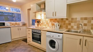 A compact kitchen with a dishwasher, oven, and washing machine.