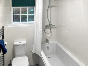 Une salle de bain avec des toilettes, une douche et une fenêtre.