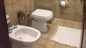 Ein Badezimmer mit Toilette, Bidet und Handtuchhalter.